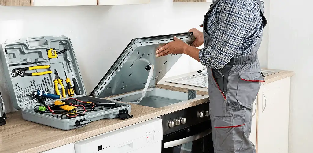 Handyman repairing a cooktop and checking wiring connections in Columbus, GA