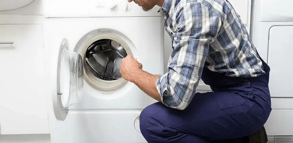 Handyman inspecting a dryer drum and internal parts for repair in Columbus, GA