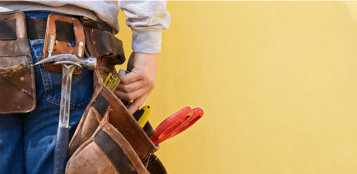 Handyman with tool belt ready for home repairs and maintenance in Columbus, GA