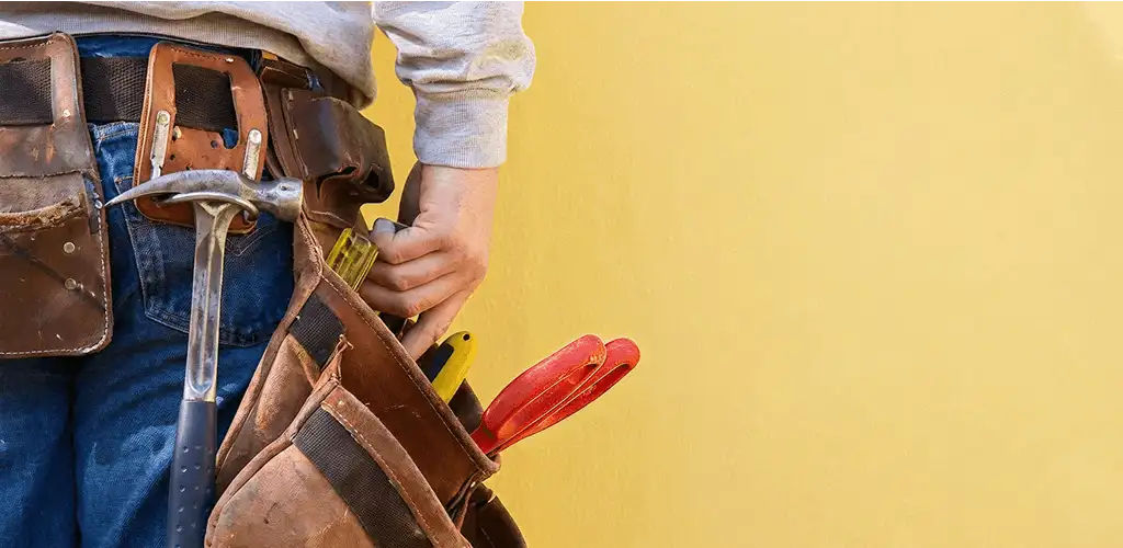 Handyman with tool belt ready for home repairs and maintenance in Columbus, GA