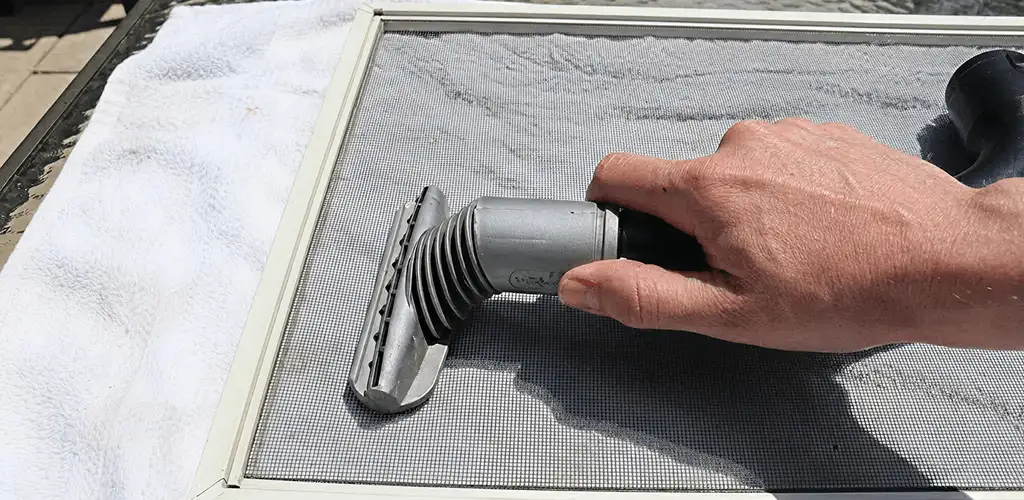 Window screen repair cleaning and fixing a damaged screen mesh in Columbus, GA